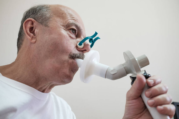 Senior Spaanse man man test ademhaling functie door spirometrie - Foto, afbeelding