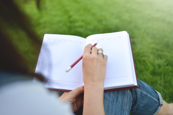 młode kobiety pisanie na notebook w parku, koncepcja w edukacji i wiedzy z bliska - Zdjęcie, obraz