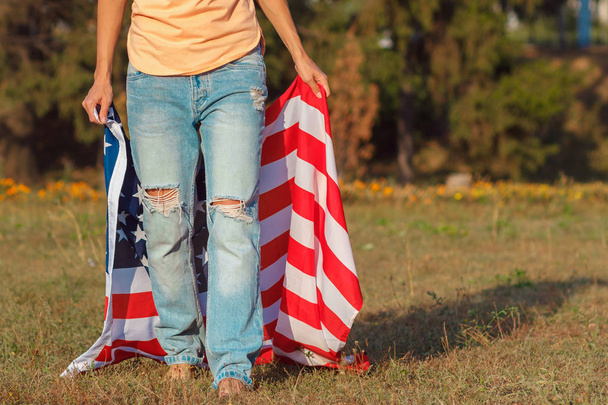 Woman with a flag of United States of America in the hands, outdoors - 写真・画像