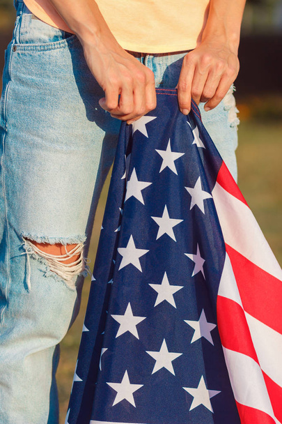 Woman with a flag of United States of America in the hand, outdoors - Foto, afbeelding
