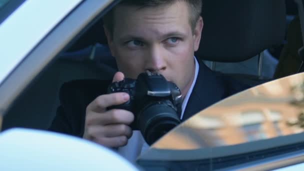 Young man secretly taking photo sitting in car, spying detective, journalist - Záběry, video
