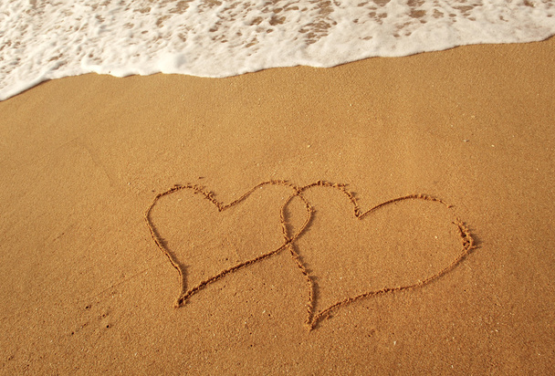 Two hearts drawn in beach - 写真・画像