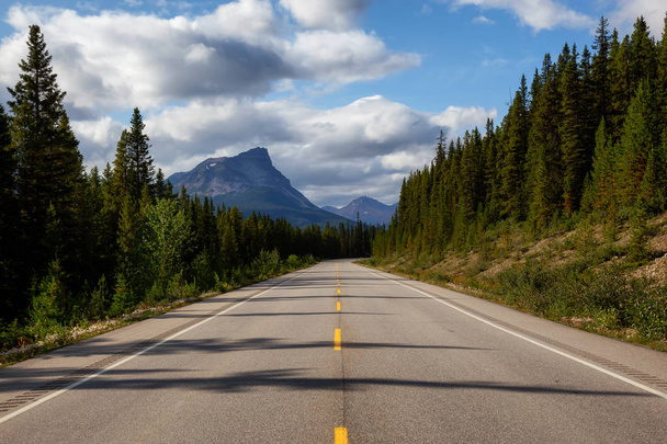 Scenic road in the Canadian Rockies during a vibrant sunny summer day. Taken in Icefields Parkway, Banff National Park, Alberta, Canada. - Φωτογραφία, εικόνα