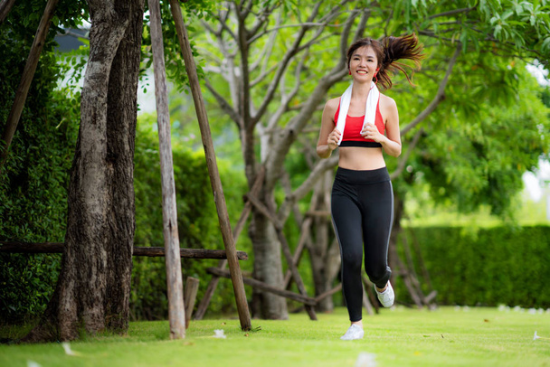 美しい夏のダに日差しの中で公園で走っているジョギング女性 - 写真・画像