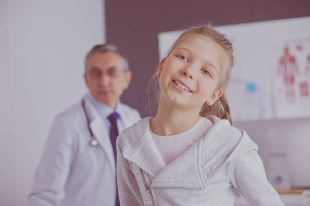 Portrait of a cute little girl and her doctor at hospital - Photo, Image