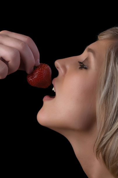 Young man feeds his girlfriend strawberries - Fotoğraf, Görsel