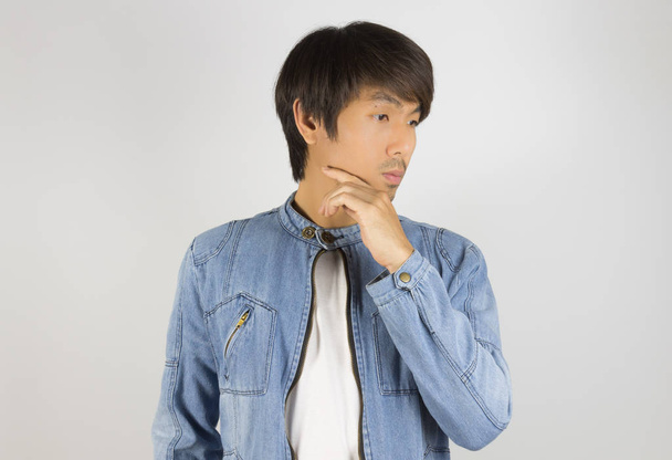 Молодой азиат в джинсах или джинсовой куртке в позе прикосновения подбородка в Центе
 - Фото, изображение