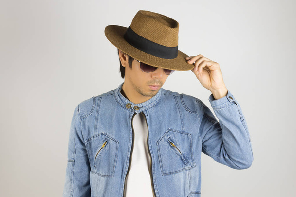 Young Asian Man in Jeans or Denim Jacket Touch Hat Brim in 45 De - Foto, Bild
