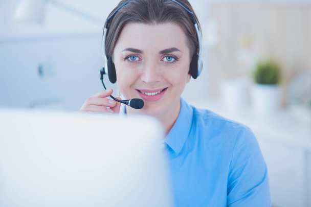 Serious pretty young woman working as support phone operator with headset in office - Foto, Imagem