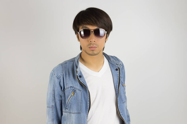 Mladý asijský muž v džínách nebo denim sako nosí sluneční brýle ve fronu - Fotografie, Obrázek