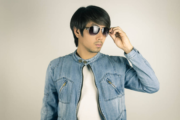 Young Man in Jeans or Denim Jacket Wear and Touch Sunglasses in  - Photo, Image
