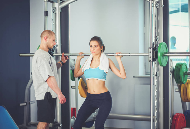 Beautiful woman at the gym exercising with her trainer. Beautiful woman. Gym - Fotó, kép