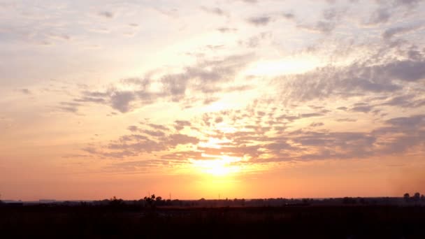 Rode en roze dramatische hemel met wolk bij zonsondergang over weide of veld. Prachtige zonsondergang hemel boven het platteland. Schilderachtige achtergrond. Buiten. - Video