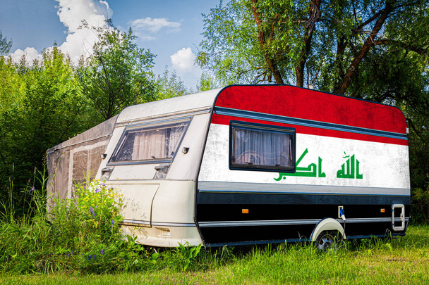 Ένα τροχόσπιτο, ένα αυτοκινητικό σπίτι, ζωγραφισμένο στην εθνική σημαία του Irak στέκεται παρκαρισμένο σε ένα ορεινό. Η έννοια των οδικών μεταφορών, του εμπορίου, των εξαγωγών και των εισαγωγών μεταξύ των χωρών. - Φωτογραφία, εικόνα