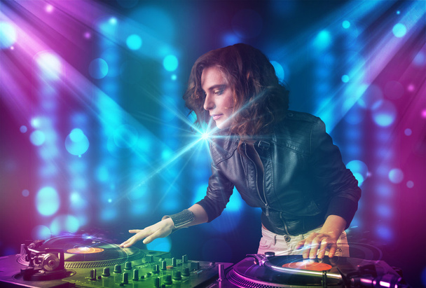 Dj girl mixing music in a club with blue and purple lights - Φωτογραφία, εικόνα