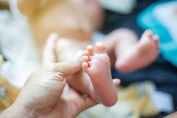 Baby feet holding by father hand massage selective focus - Fotó, kép
