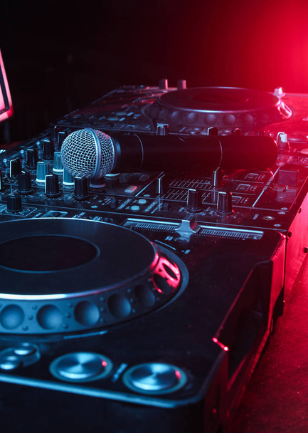 Gece kulübü, gece hayatı konsepti. Disko. DJ kumandasındaki mikrofon. Neon kırmızı mavi ışık - Fotoğraf, Görsel