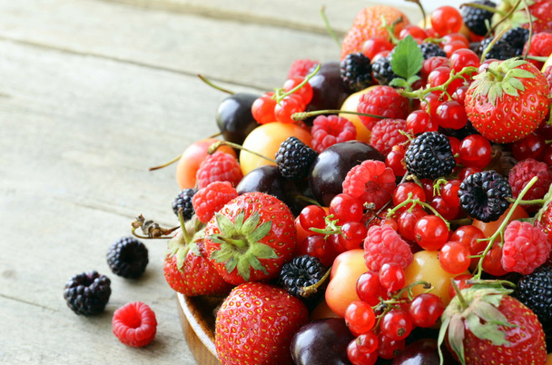 Berry assortiment - frambozen, bramen, aardbeien, aalbessen, kersen - Foto, afbeelding
