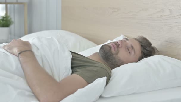 Nukkuva nuori mies sängyssä kotona - Materiaali, video