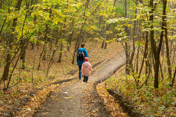 Madre e hija están caminando en el bosque de otoño
 - Foto, imagen