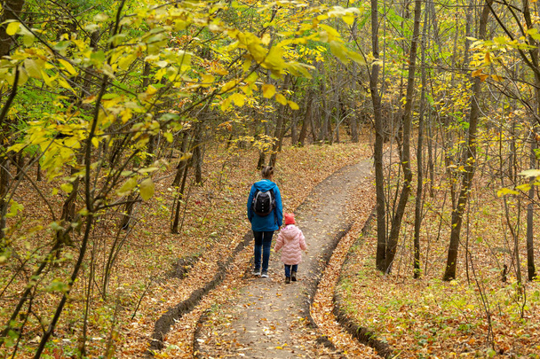 Мать и дочь гуляют по осеннему лесу
 - Фото, изображение