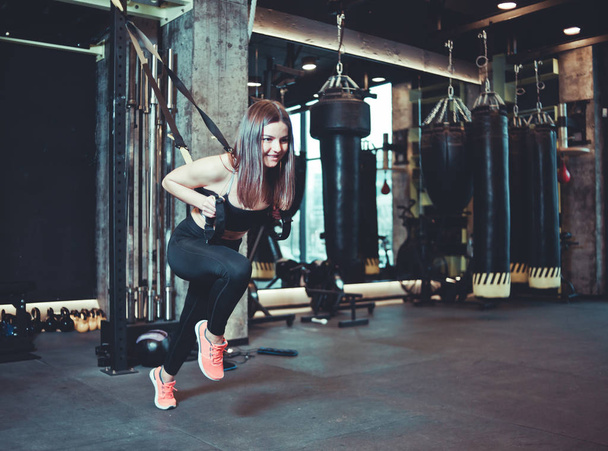 Mujer en forma haciendo ejercicio con correa de fitness en el gimnasio. Entrenamiento, entrenamiento funcional. Estilo de vida deportivo - Foto, Imagen