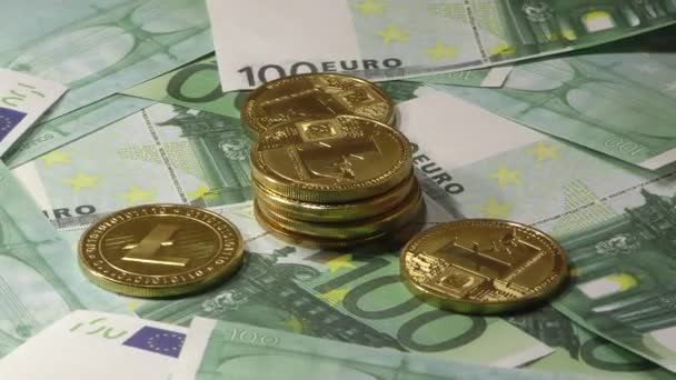A 100 euro-bankjegyek számláin forgó fényérmék LTC-érmék. Világméretű virtuális internetes cryptocurrency. - Felvétel, videó
