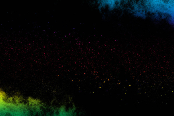 Multi gekleurde poeder explosie op zwarte achtergrond. Kleurrijke Dust splash Cloud op donkere achtergrond. - Foto, afbeelding