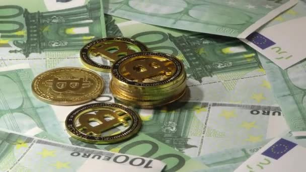 Монеты Gold Bit Coin BTC вращаются на банкнотах номиналом 100 евро. Всемирная виртуальная интернет-криптовалюта
. - Кадры, видео