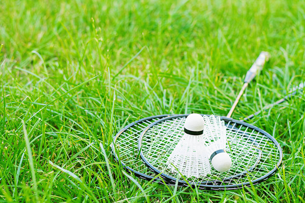 Raquetes de vaivém e badminton em um gramado verde
 - Foto, Imagem