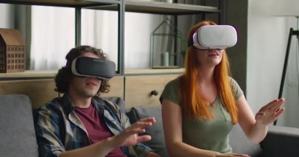 Mladá žena a muž Vychutnejte si své nové sluchátka VR doma - Záběry, video