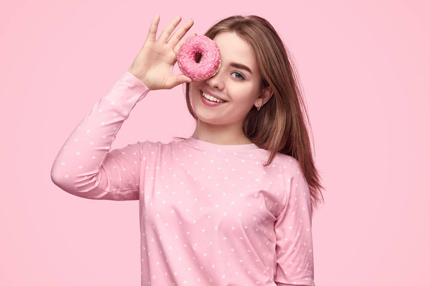 Cheerful teenager with yummy donut - 写真・画像