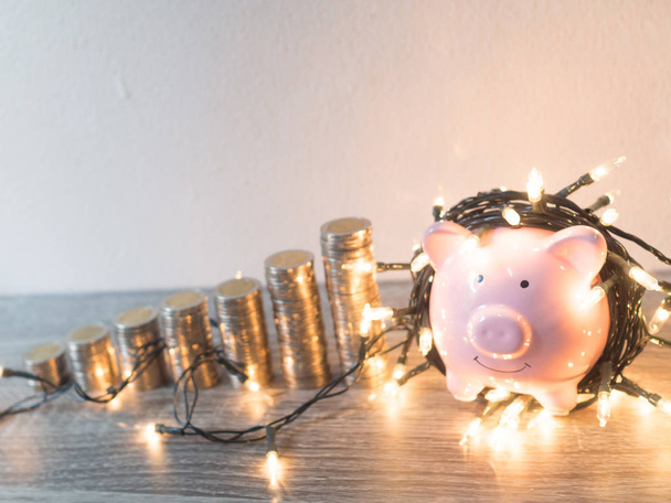 Ροζ κουμπαράς με κέρματα διάγραμμα ανάπτυξης στοίβα και φώτα κόμμα, χαρούμενη εξοικονόμηση χρημάτων για το μελλοντικό επενδυτικό σχέδιο και το συνταξιοδοτικό ταμείο έννοια - Φωτογραφία, εικόνα