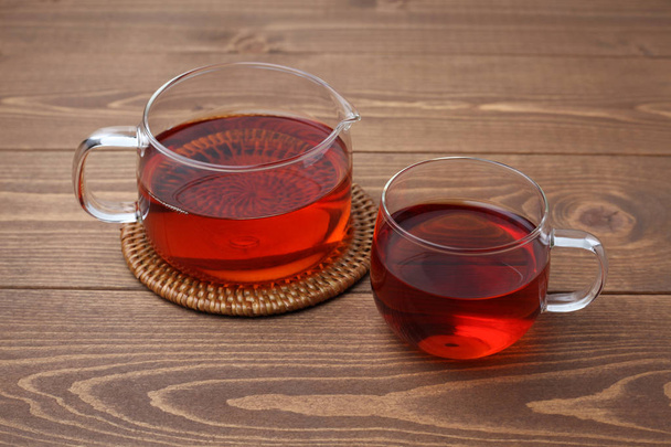 kopje thee en thee pot geïsoleerd op houten tafel - Foto, afbeelding
