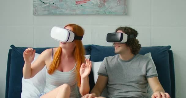 Young Couple Has Fun in Bedroom, Using VR Headsets - Кадры, видео
