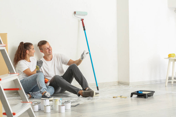 glückliches junges Paar diskutiert Reparatur seines neuen Hauses - Foto, Bild