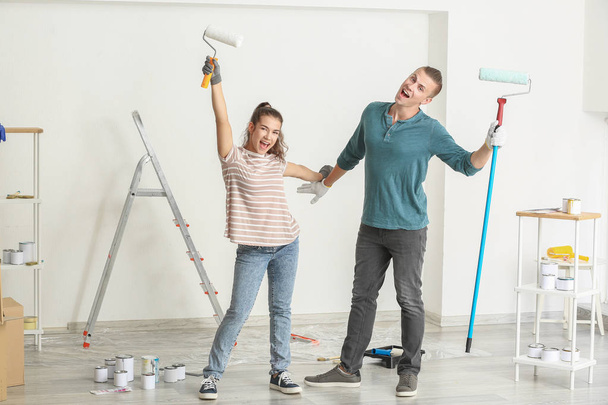 Счастливая молодая пара веселится, делая ремонт в своем новом доме
 - Фото, изображение