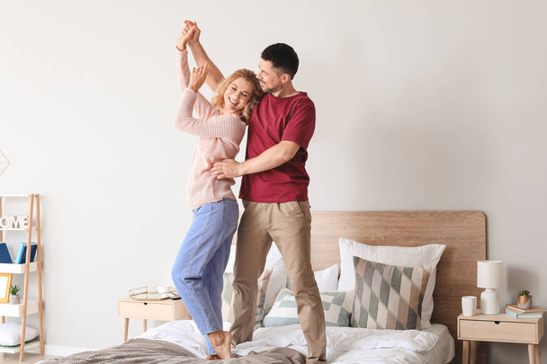 Happy dancing couple in bedroom - Valokuva, kuva