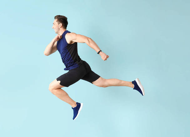 Correndo homem desportivo no fundo de cor
 - Foto, Imagem