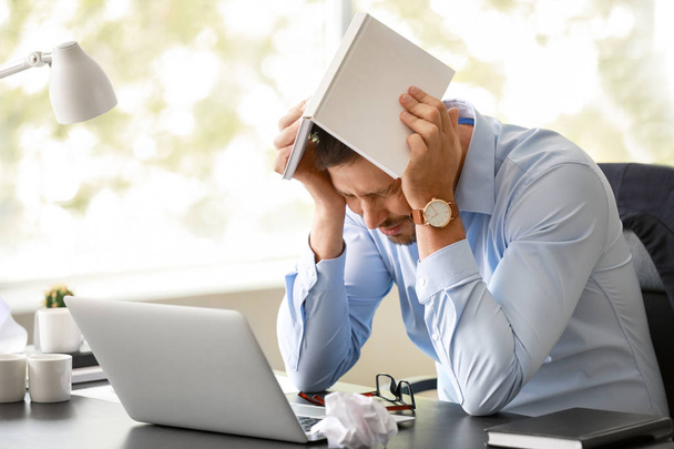 Стрессовый человек за столом в офисе
 - Фото, изображение