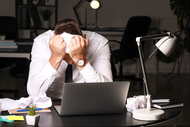 Homem estressado no local de trabalho tarde da noite
 - Foto, Imagem
