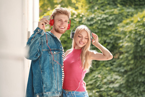 Jovem casal ouvindo música ao ar livre
 - Foto, Imagem