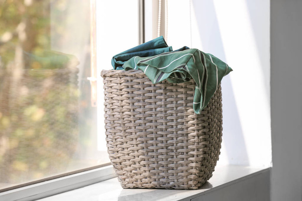 Basket with laundry on window sill - 写真・画像