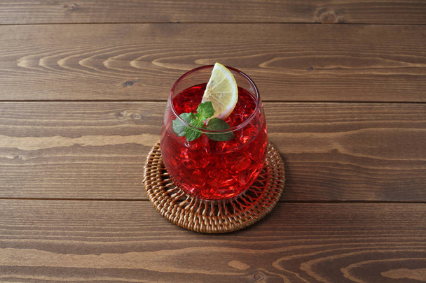 verre de thé froid boisson rouge isolé sur une table en bois
 - Photo, image