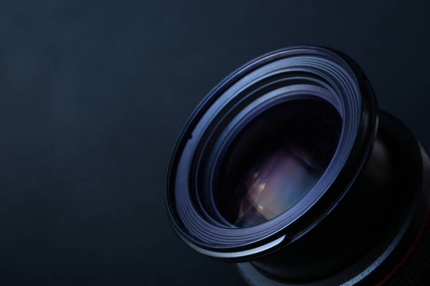 Lens of professional camera on dark blue background, closeup. Space for text - Foto, Imagem