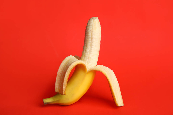 Fresh banana on red background. Sex concept - Фото, изображение