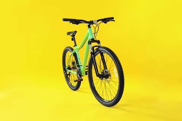 Modern bicycle on yellow background. Healthy lifestyle - 写真・画像