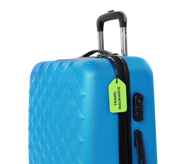 Blue suitcase with TRAVEL INSURANCE label on white background - 写真・画像