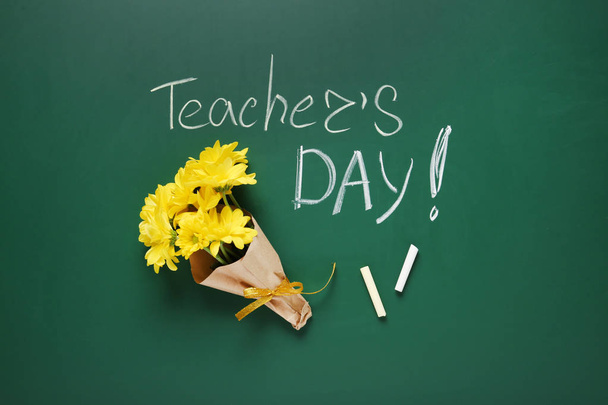 Flat lay composition with flowers and inscription TEACHER'S DAY on green chalkboard - Fotografie, Obrázek