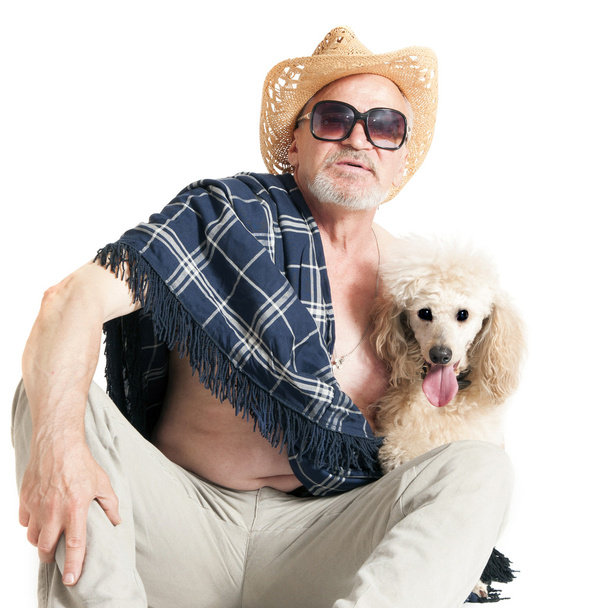 Homem de chapéu sentado com um poodle
 - Foto, Imagem